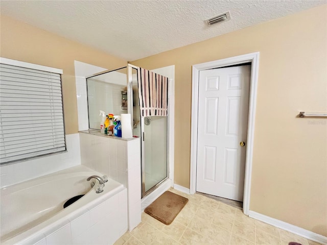 bathroom featuring tile patterned floors, independent shower and bath, and a textured ceiling