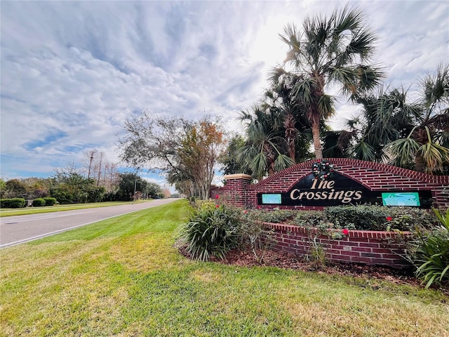 community / neighborhood sign featuring a lawn