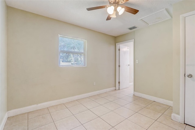 tiled spare room featuring a textured ceiling and ceiling fan