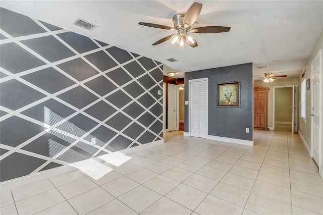 unfurnished living room featuring light tile patterned floors and ceiling fan