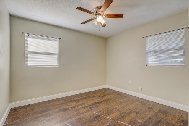 spare room with dark hardwood / wood-style floors, ceiling fan, and a textured ceiling