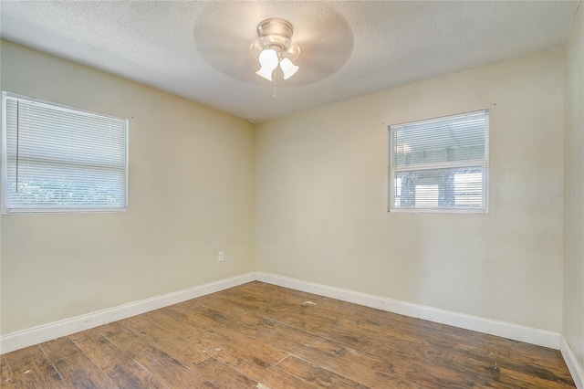 empty room with ceiling fan, hardwood / wood-style floors, and a textured ceiling