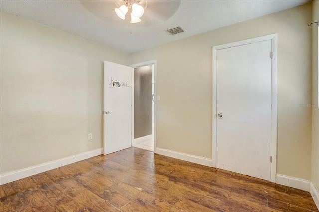 unfurnished room featuring hardwood / wood-style flooring, ceiling fan, and a textured ceiling