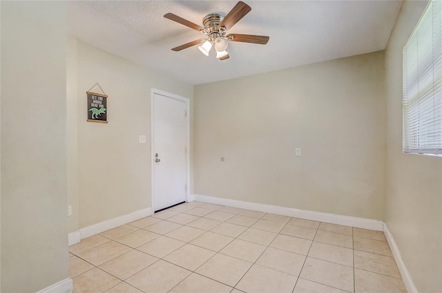 tiled spare room featuring ceiling fan and a textured ceiling