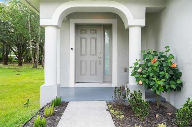 property entrance featuring a lawn