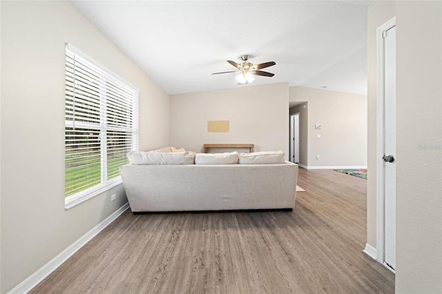 living room featuring ceiling fan, light hardwood / wood-style floors, and lofted ceiling