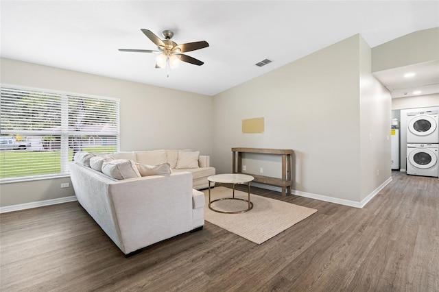 living room with stacked washer / dryer, ceiling fan, wood-type flooring, and lofted ceiling