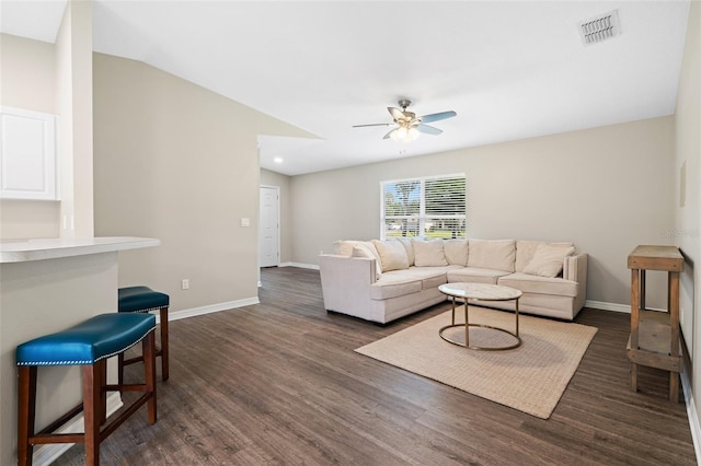 living room with ceiling fan, dark wood-type flooring, and vaulted ceiling