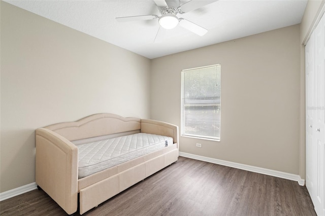 bedroom with ceiling fan, dark hardwood / wood-style flooring, and a closet