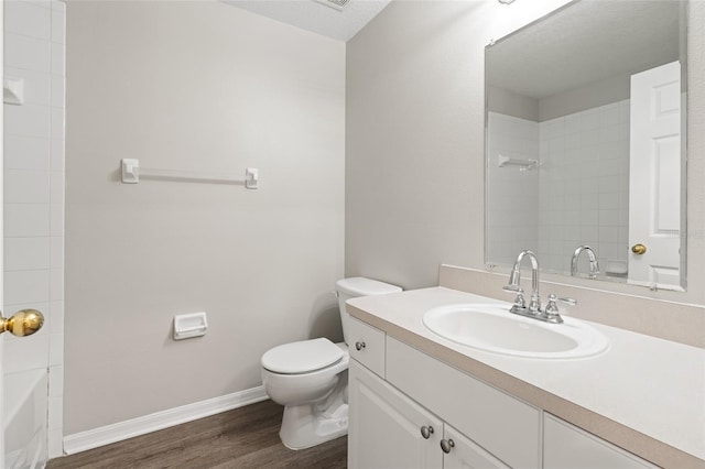 bathroom featuring hardwood / wood-style flooring, vanity, toilet, and a textured ceiling