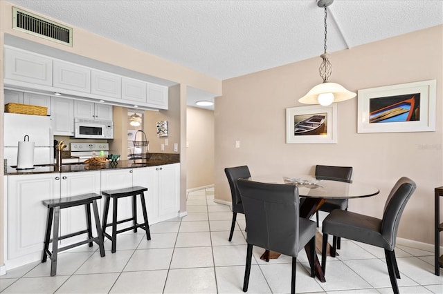 tiled dining room with a textured ceiling