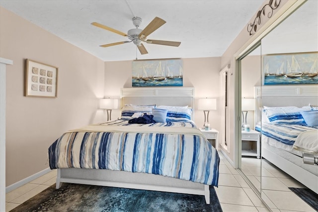 tiled bedroom with ceiling fan and a closet