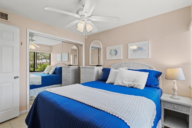 tiled bedroom with ceiling fan and a closet