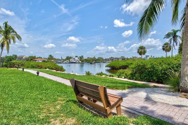 view of property's community featuring a lawn and a water view