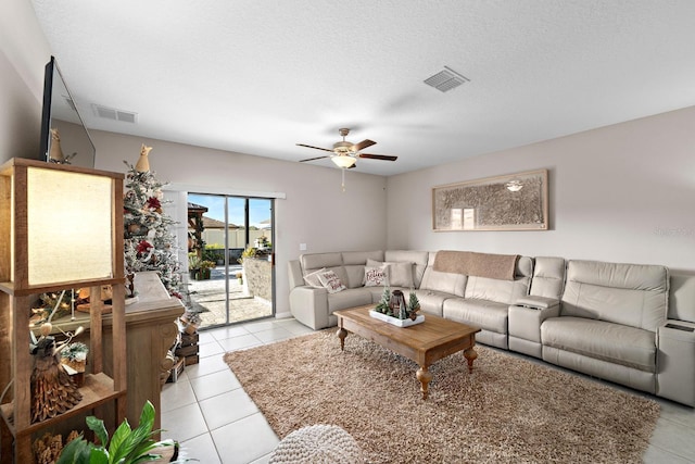 tiled living room with a textured ceiling and ceiling fan