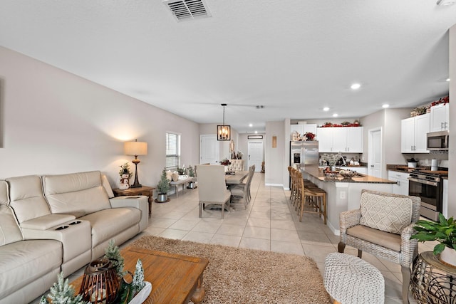 living room featuring sink and light tile patterned flooring