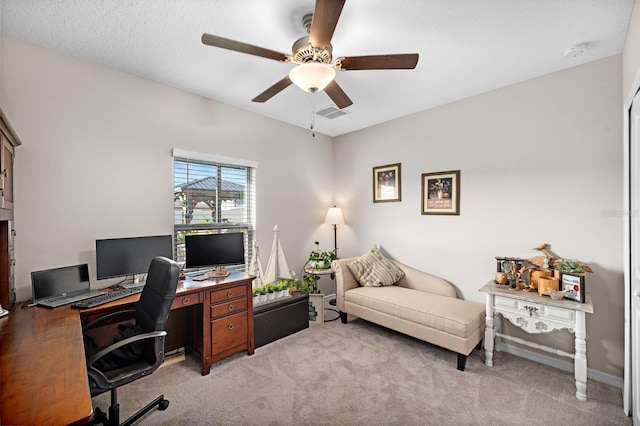 office featuring ceiling fan, light colored carpet, and a textured ceiling