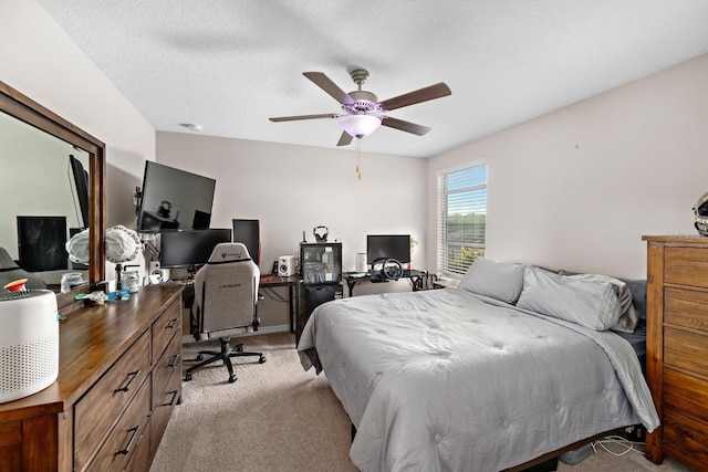 bedroom featuring light carpet, a textured ceiling, and ceiling fan