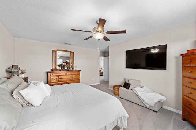 carpeted bedroom featuring a textured ceiling and ceiling fan