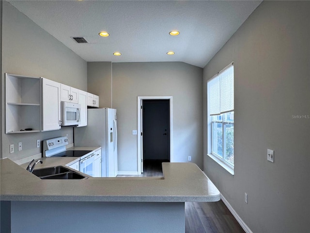 kitchen with sink, vaulted ceiling, kitchen peninsula, white appliances, and white cabinets