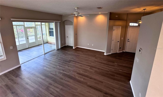 spare room with ceiling fan, a textured ceiling, and dark hardwood / wood-style flooring