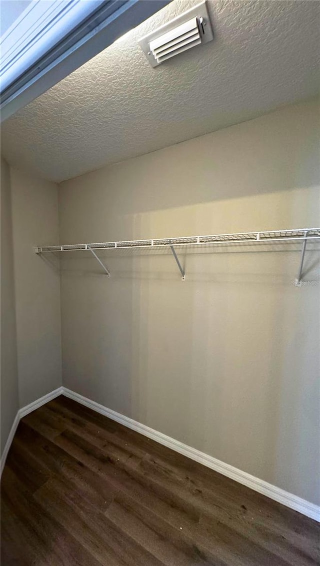 walk in closet featuring dark wood-type flooring