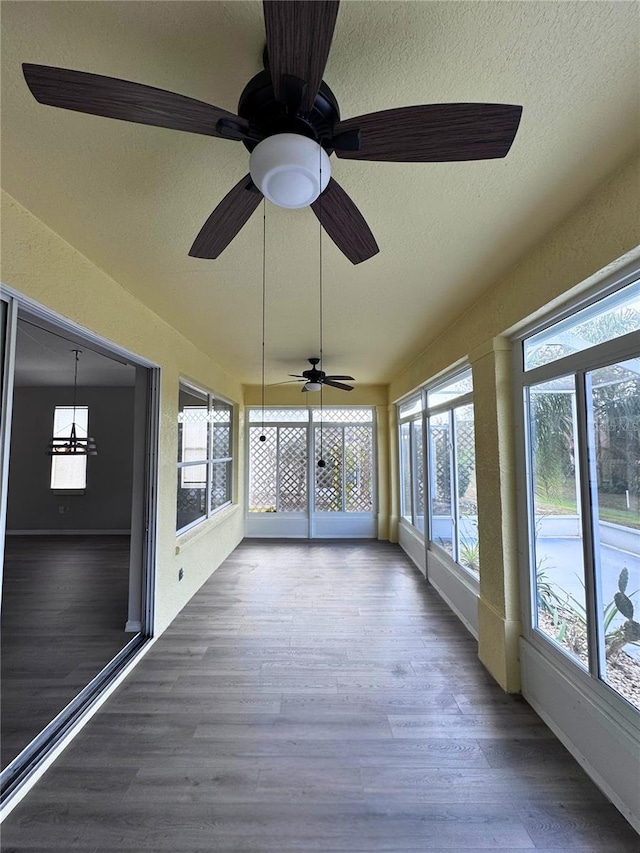 unfurnished sunroom with a healthy amount of sunlight and ceiling fan