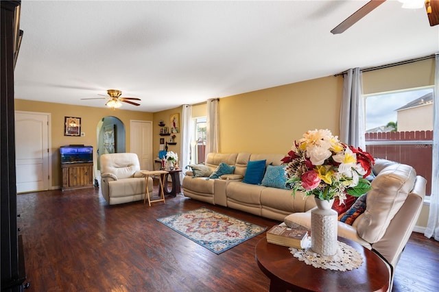 living room with dark wood-type flooring and a healthy amount of sunlight