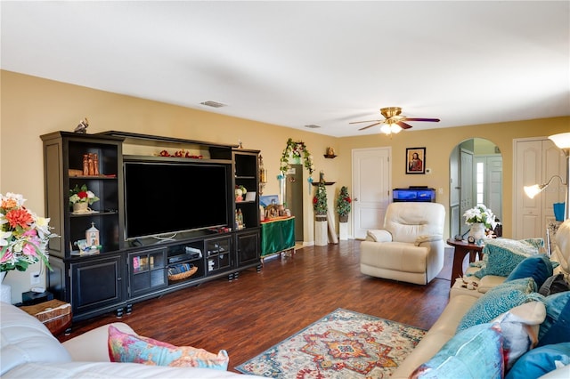 living room with ceiling fan and dark wood-type flooring