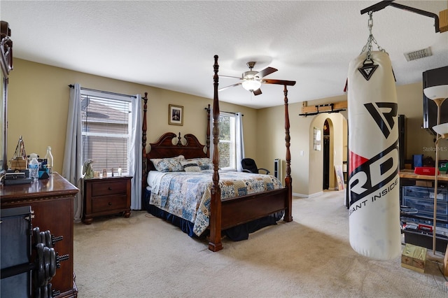 bedroom with light carpet, a textured ceiling, and ceiling fan