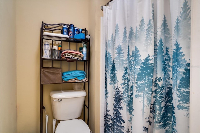 bathroom featuring a shower with curtain and toilet