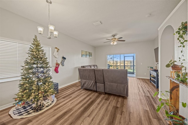 living room with hardwood / wood-style flooring and ceiling fan with notable chandelier