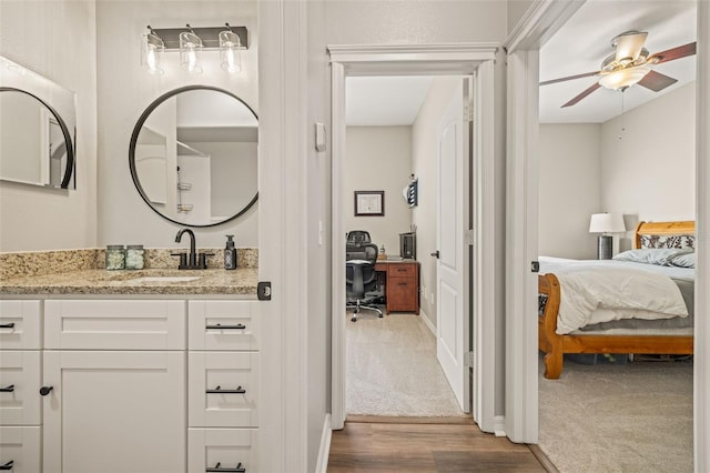 bathroom featuring wood-type flooring, vanity, and ceiling fan