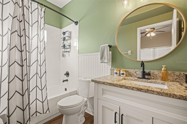 full bathroom featuring vanity, ceiling fan, toilet, shower / bathtub combination with curtain, and wood-type flooring