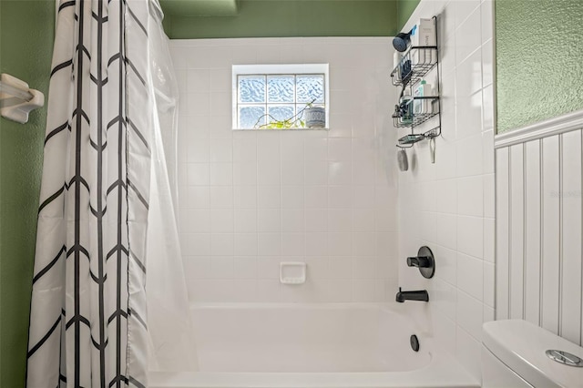 bathroom featuring shower / bath combination with curtain and toilet