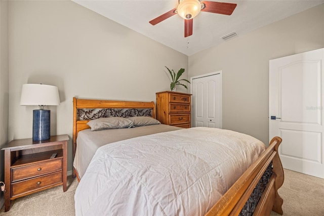 carpeted bedroom with vaulted ceiling, a closet, and ceiling fan