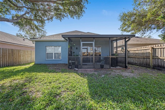 back of house with a sunroom and a lawn