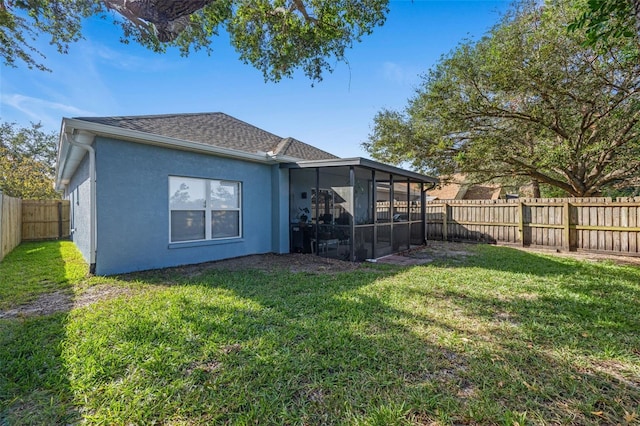 rear view of property featuring a lawn and a sunroom