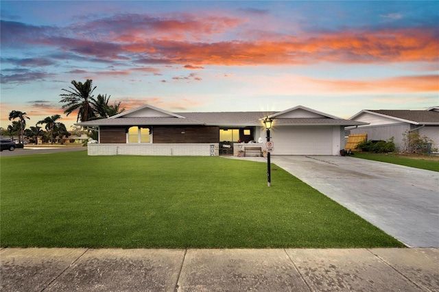 ranch-style home with a garage and a lawn