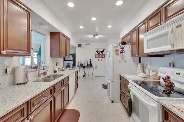 kitchen featuring white appliances, backsplash, sink, ceiling fan, and light stone countertops