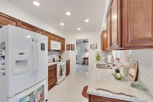 kitchen featuring white appliances, sink, decorative backsplash, ceiling fan, and light stone countertops