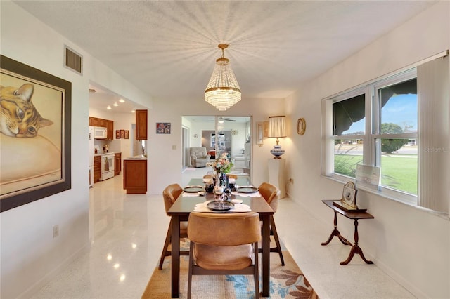 dining room with a textured ceiling and an inviting chandelier