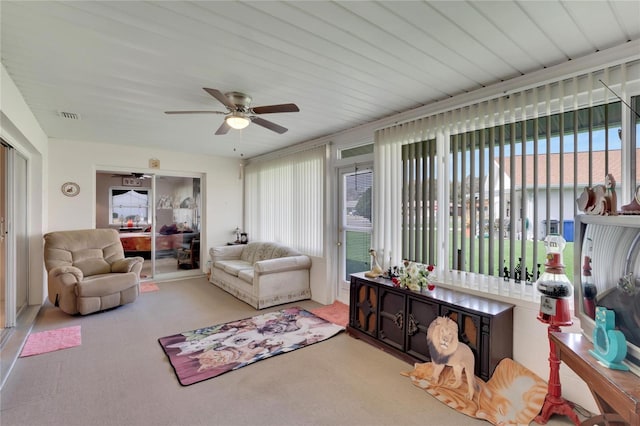 carpeted living room with ceiling fan and plenty of natural light