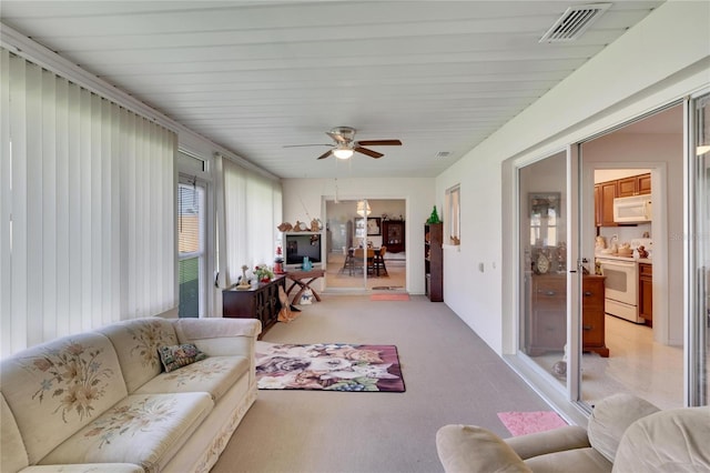 carpeted living room with ceiling fan