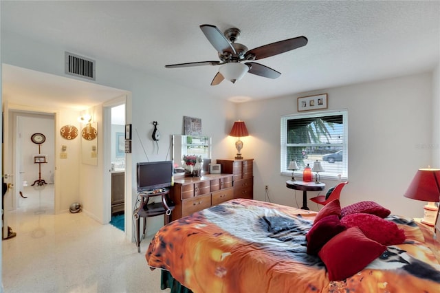 bedroom featuring a textured ceiling, ensuite bathroom, and ceiling fan