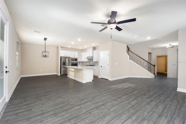 unfurnished living room with ceiling fan, sink, and dark wood-type flooring