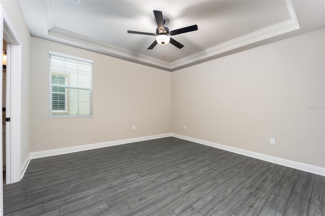 unfurnished room with a textured ceiling, dark hardwood / wood-style floors, crown molding, and a tray ceiling