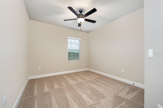 carpeted spare room featuring ceiling fan