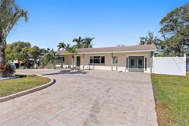 back of property with a lawn and french doors