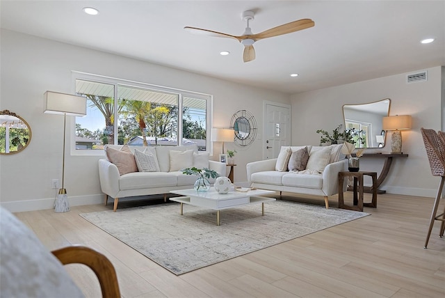 living room featuring light hardwood / wood-style flooring and ceiling fan